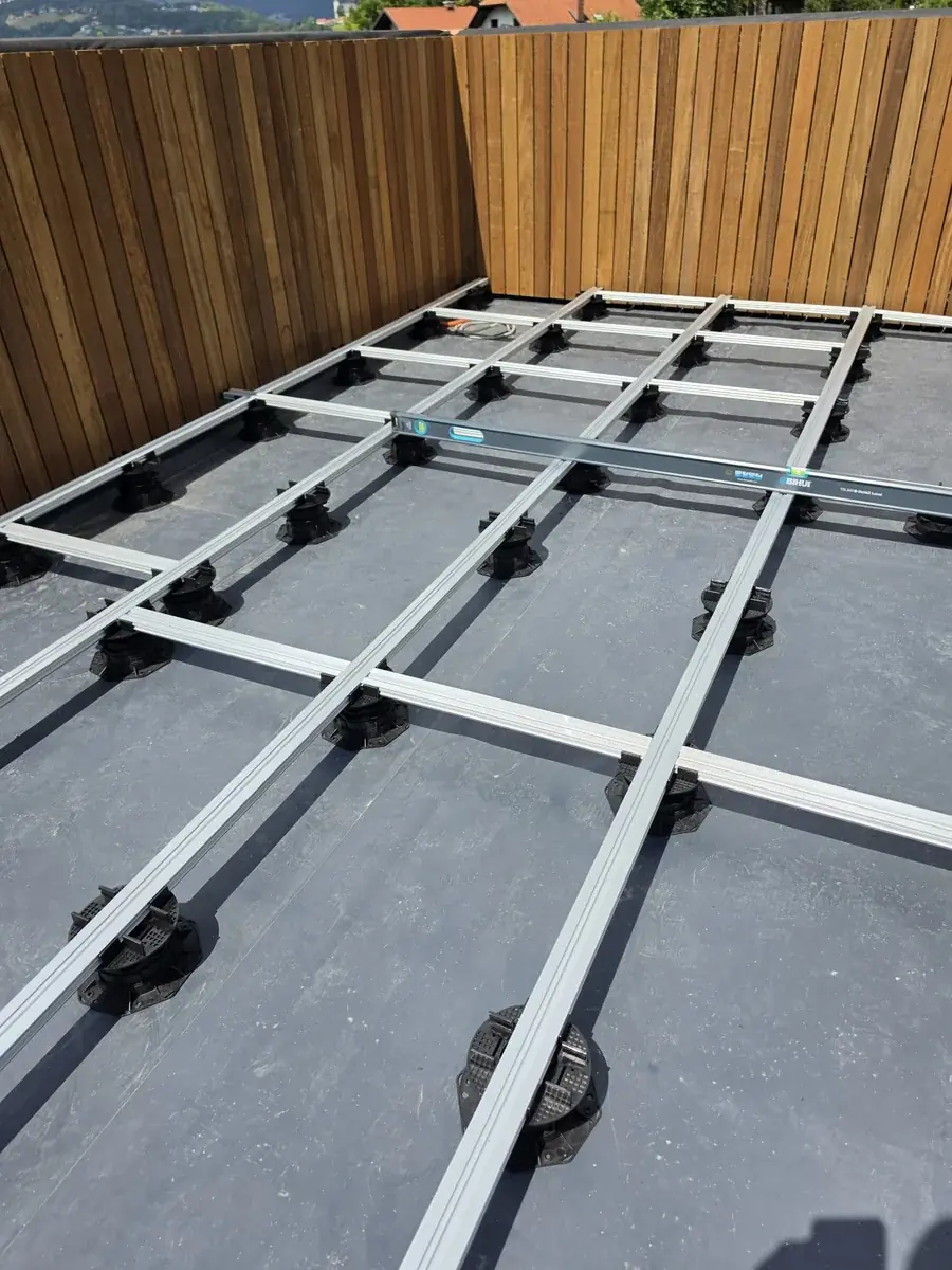 Pedestal and joist grid along the timber privacy screen at a Slovenia mansion rooftop
