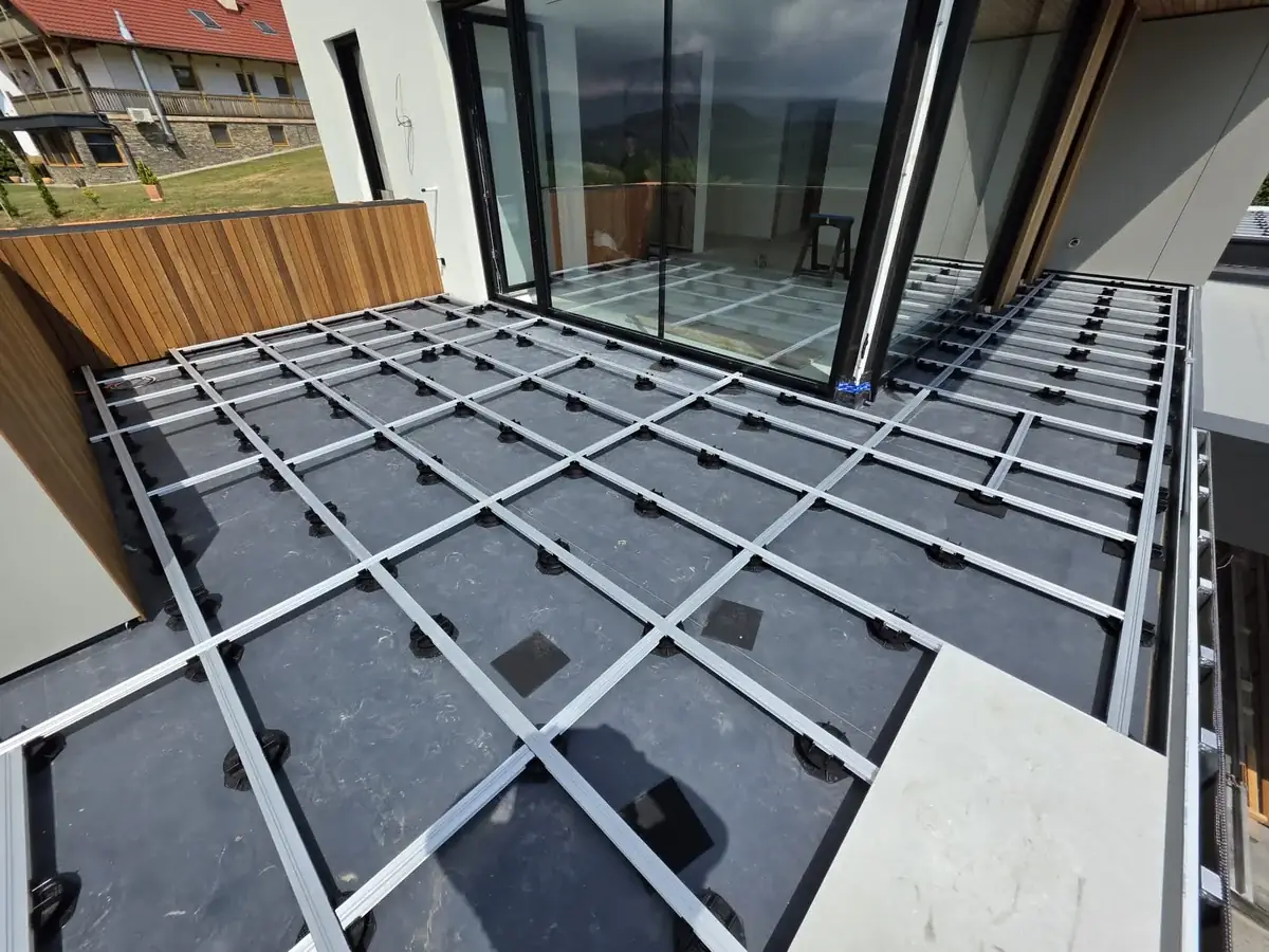 Pedestal grid meeting the full-height window frame at a Slovenia mansion rooftop