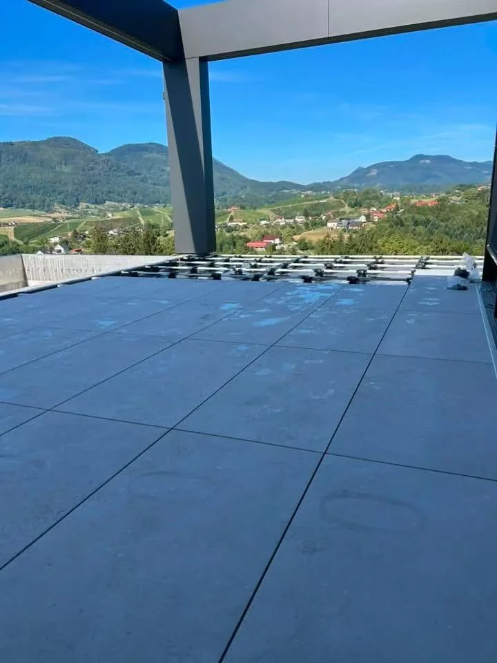 Dark porcelain rooftop finish installed on adjustable pedestals at a Slovenia mansion
