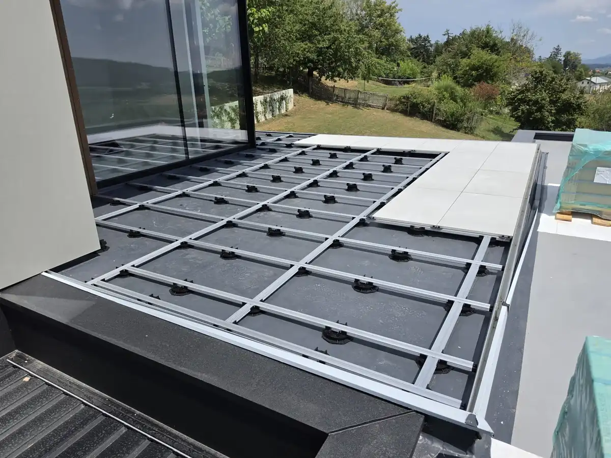 Pedestal grid meeting the vertical timber privacy screen at the edge of a Slovenia mansion rooftop